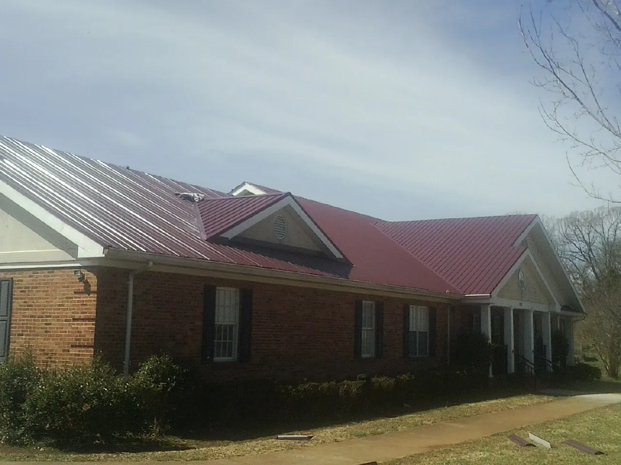 Red metal roof with gabled entries on a long brick building in Rollinsville