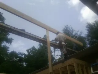 Carpenter setting a ridge beam over a new addition frame — Ice Dam Removal by Roofing Brothers in Rollinsville