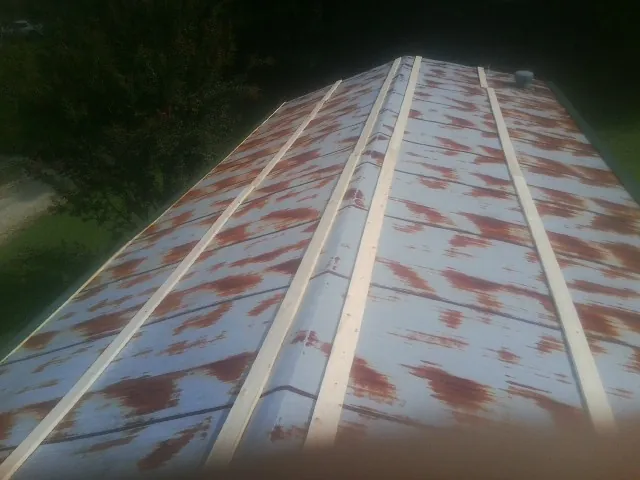 Rusted metal roof panels with new wood purlins before replacement — Storm Damage Roof Repair in Rollinsville by Roofing Brothers
