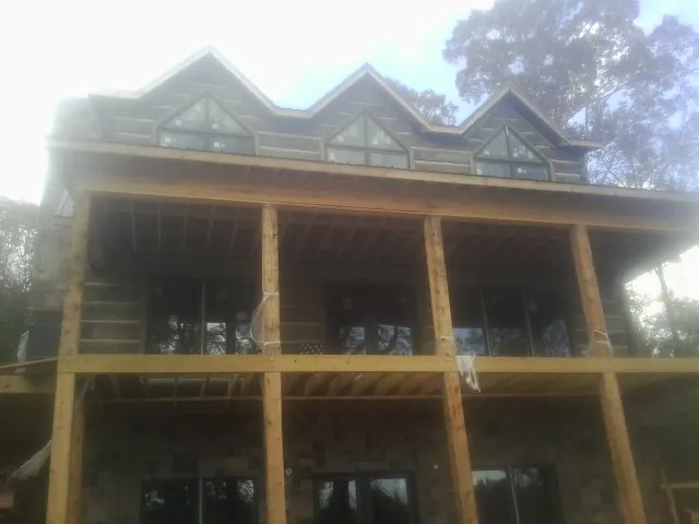 Dormers and porch framing on a large log home under construction — Roof Coating work by our crew in Rollinsville